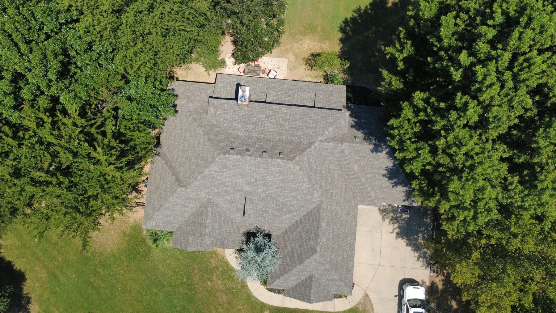 Aerial view of a completed Oklahoma roof surrounded by trees