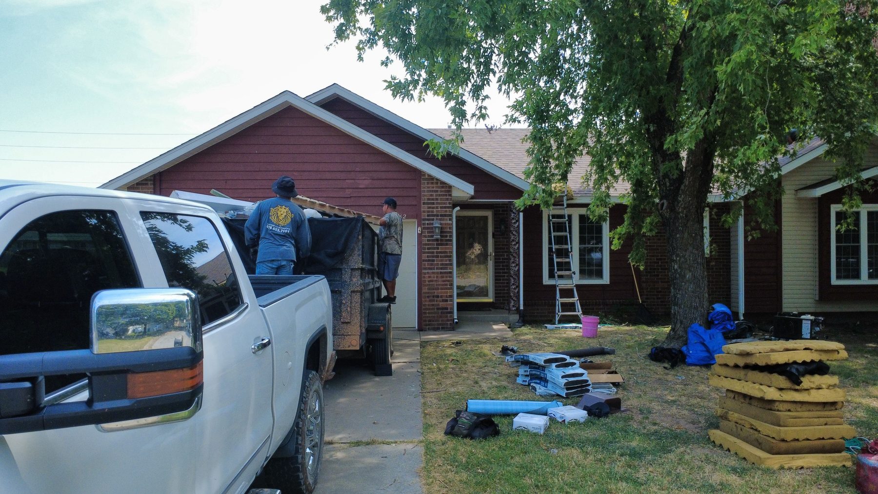 CRE Roofing crew unloading materials at an Oklahoma City job site