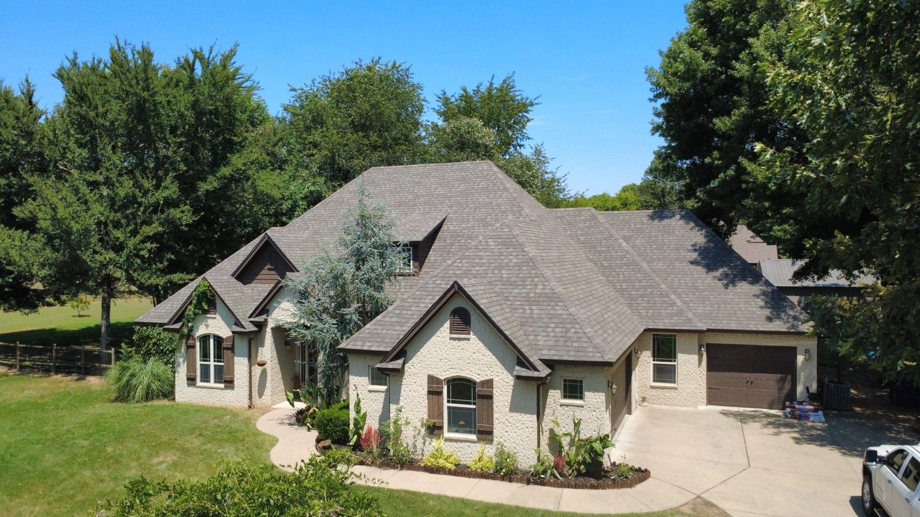 Completed CRE Roofing shingle roof on a stone home outside Oklahoma City