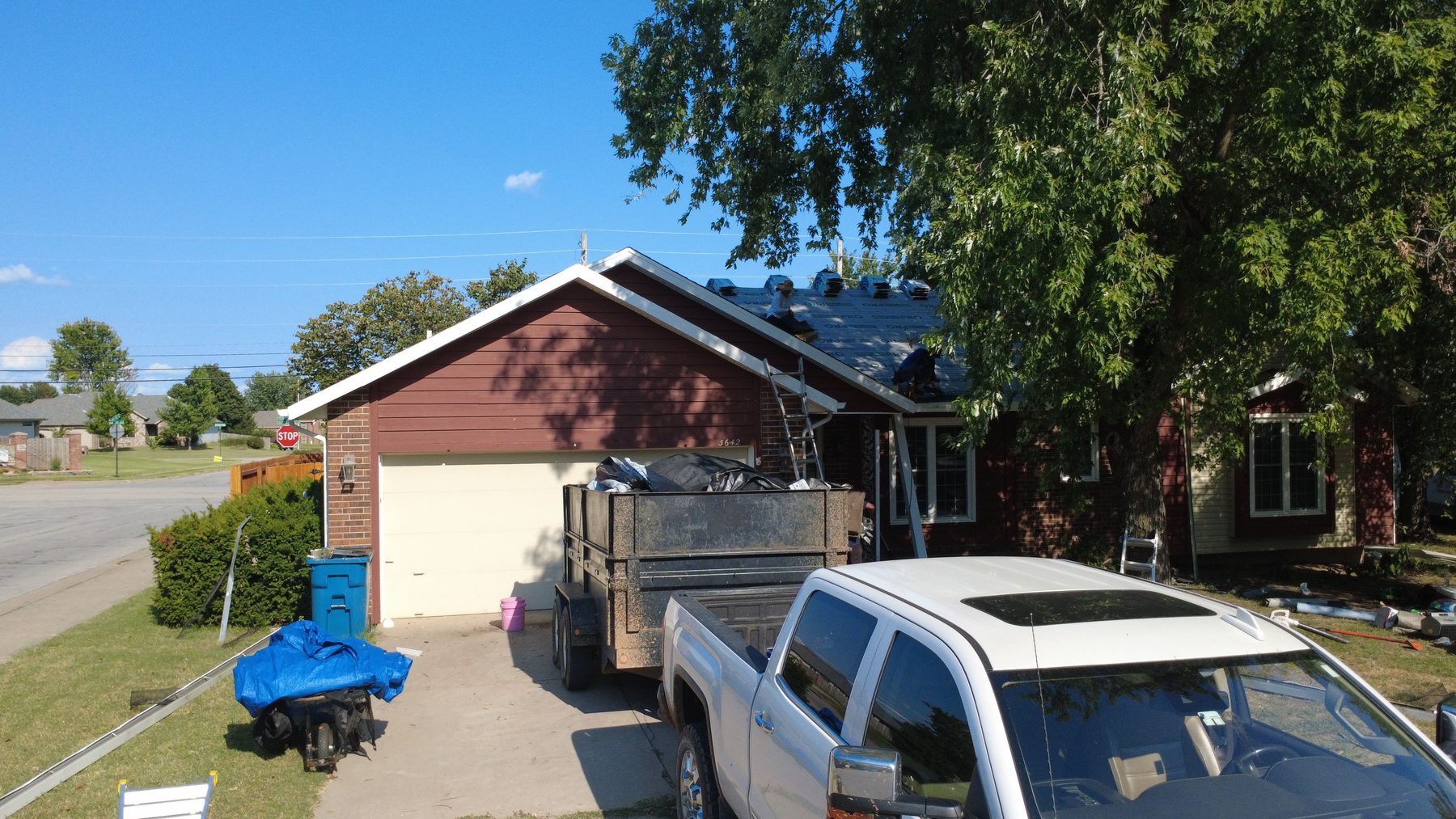 CRE Roofing truck and dump trailer at an Oklahoma roof replacement