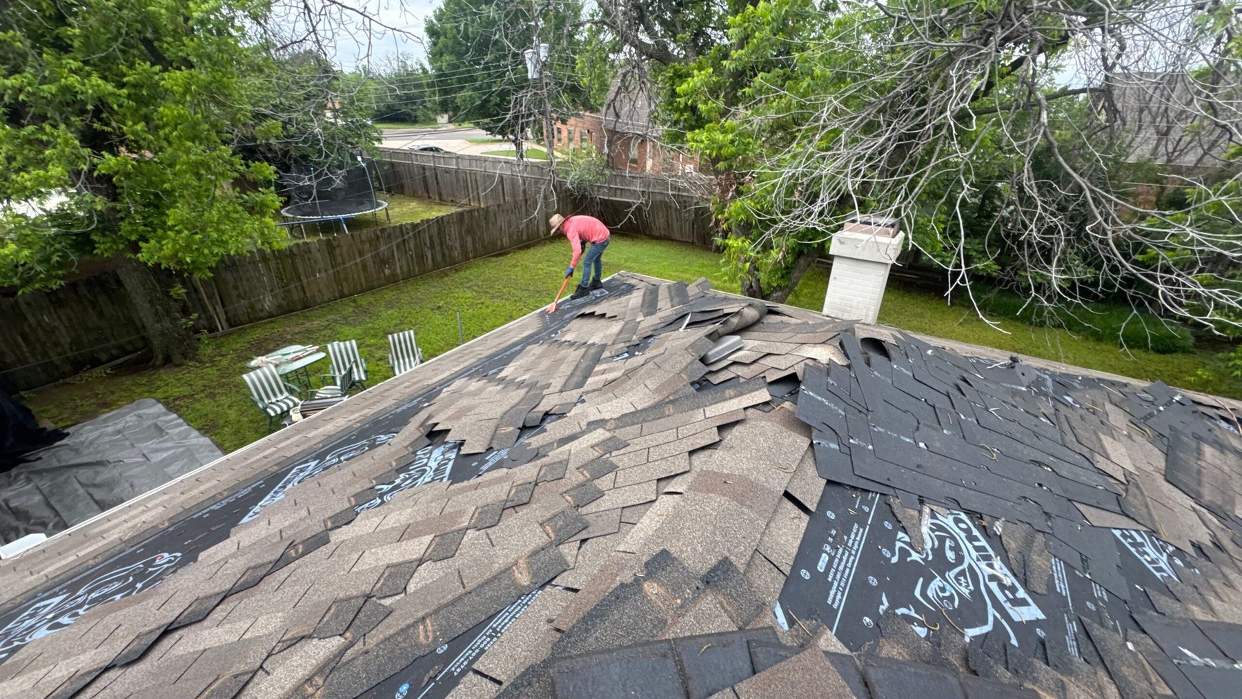 CRE Roofing crew tearing off old shingles on an Oklahoma City home