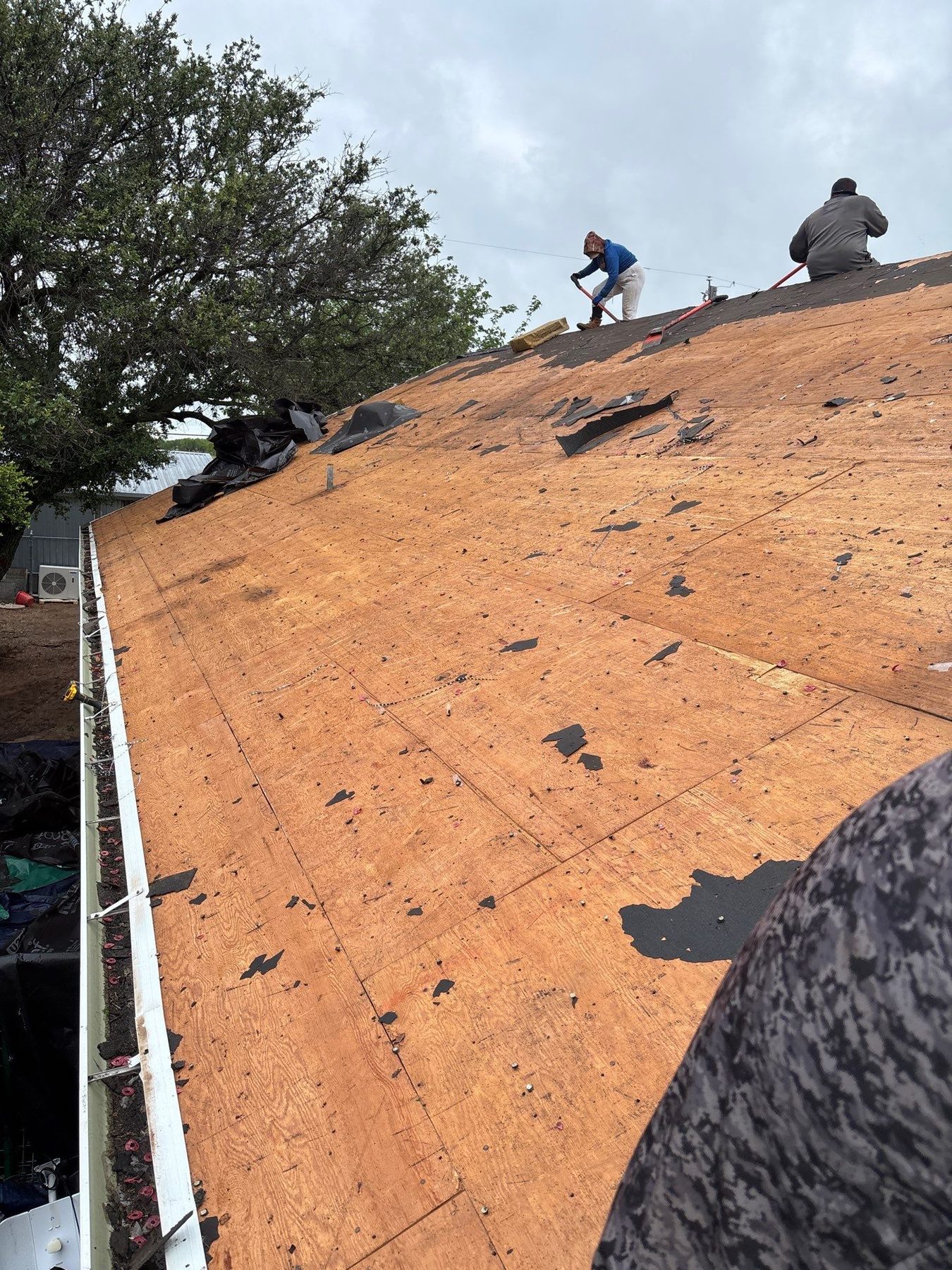Roofer working a tear-off on an Oklahoma roof