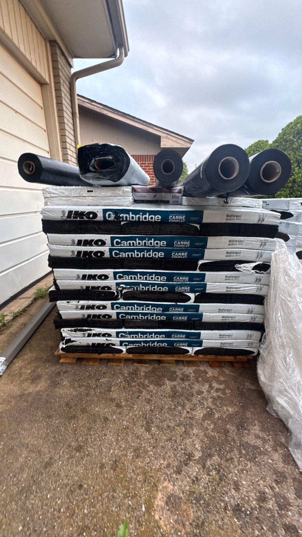 Architectural shingle bundles staged in a driveway